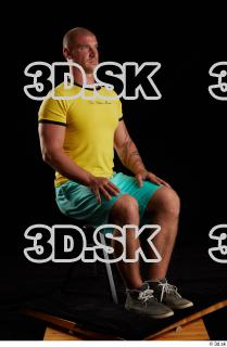 Sitting reference of whole yellow shirt turquoise shorts brown shoes…